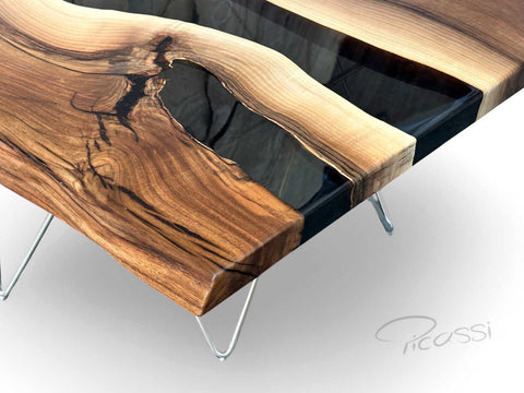 Tisch aus Nussbaum Massivholz mit Epoxidharz auf einem denzenten Edelstahl Gestell